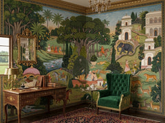 Indian miniature painting wallpaper in a study with green wingback chair and antique desk.