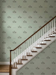 Sage green goats wallpaper on a staircase wall.
