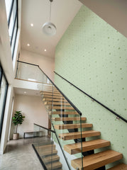 Sage polka dot wallpaper on a staircase wall.