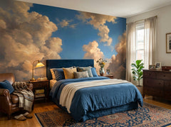 Golden painted cloud wallpaper behind the bed in a bedroom with navy bedding.