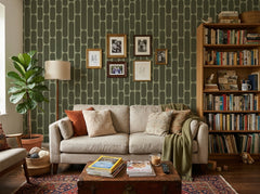 Olive green retro capsule wallpaper in a cozy living room with cream sofa and bookshelf.