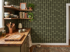 Olive green retro capsule wallpaper in a kitchen with wooden countertop and shelves.
