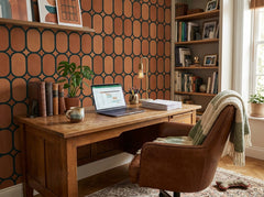 Terracotta oval trellis wallpaper in a home office with wooden desk.
