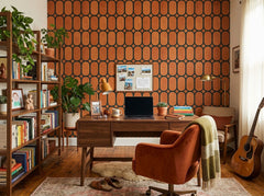 Terracotta oval trellis wallpaper in a home office with velvet chair and guitar.