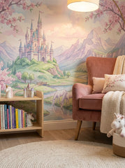 Pink fairytale castle wallpaper in a reading nook with a pink velvet armchair and a bookshelf.