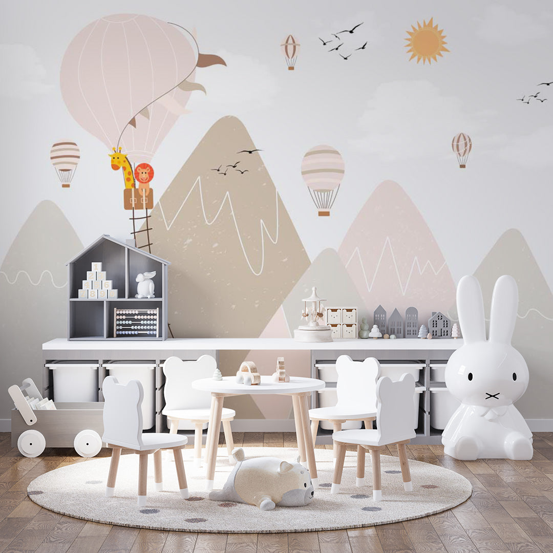 Pastel kids room wallpaper with a giraffe and lion in a hot-air balloon above mountains, birds, smaller balloons, and a golden sun.