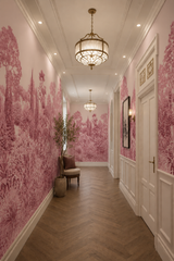 Rose botanical wallpaper in a long elegant hallway with white wall paneling, brass lighting and herringbone wood floor.