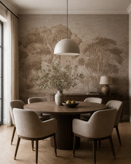 Taupe painted trees wallpaper in a dining room with a round table.