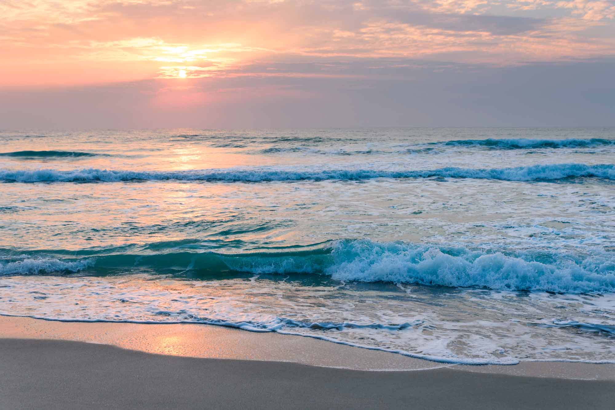 Spokojny wschód słońca nad falami oceanu Tapeta ścienna